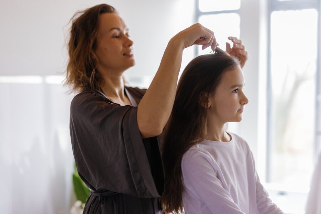 woman tying up child's hair