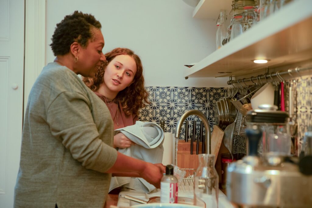 woman and teenage girl washing dishes together