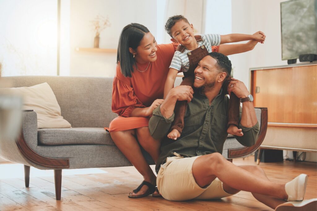 two adults with child on sofa